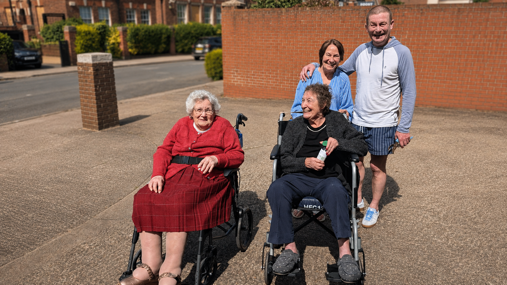Residents and Royal Court care team members enjoying the afternoon outdoors, smiling at the camera.